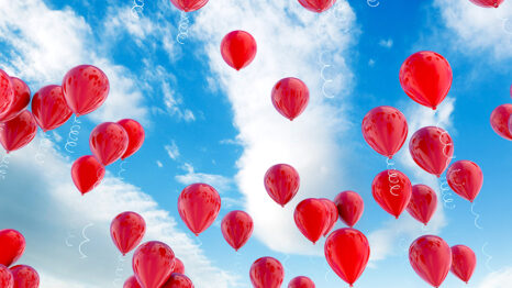 Red balloons floating in the sky